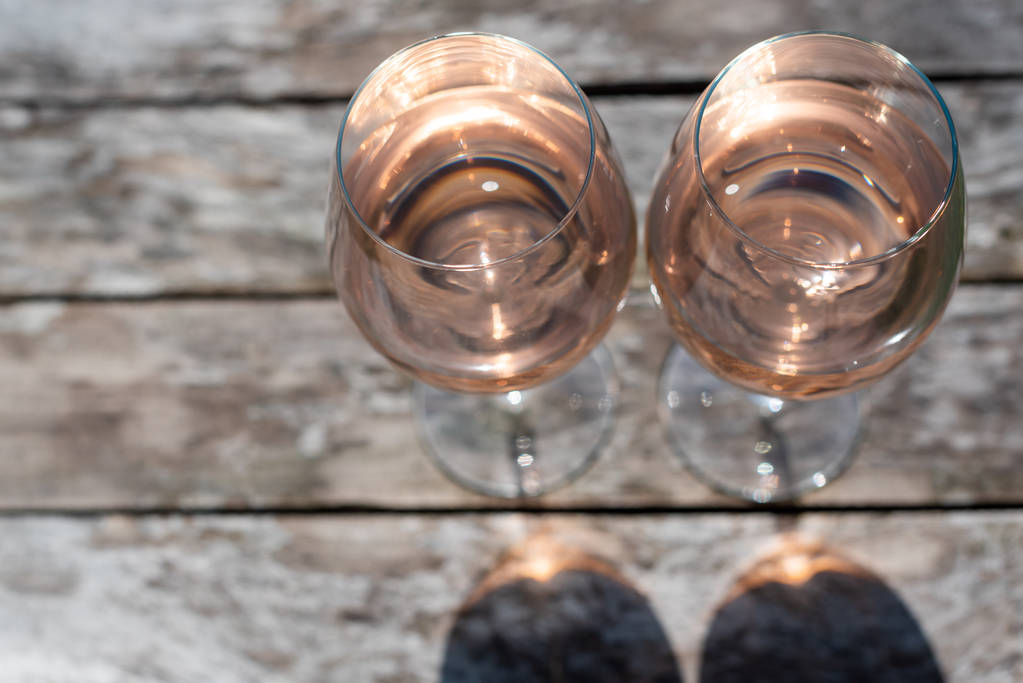 Дві склянки трояндового вина на дерев'яному столі
 - Фото, зображення