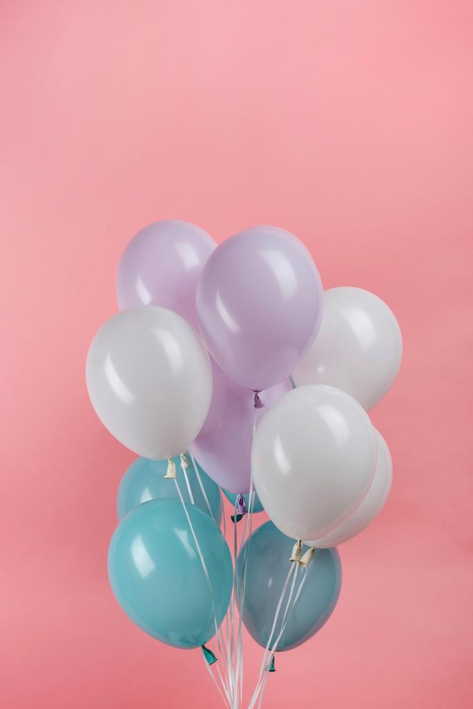 ピンクの背景に白青紫のお祝いの風船 ロイヤリティフリー写真 画像素材