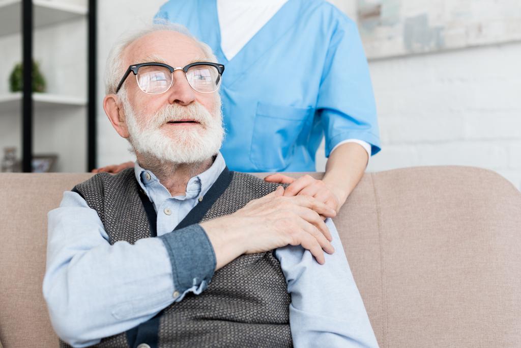 Lekarz wspierający pacjentów w podeszłym wieku, kładąc ręce na ramieniu - Zdjęcie, obraz