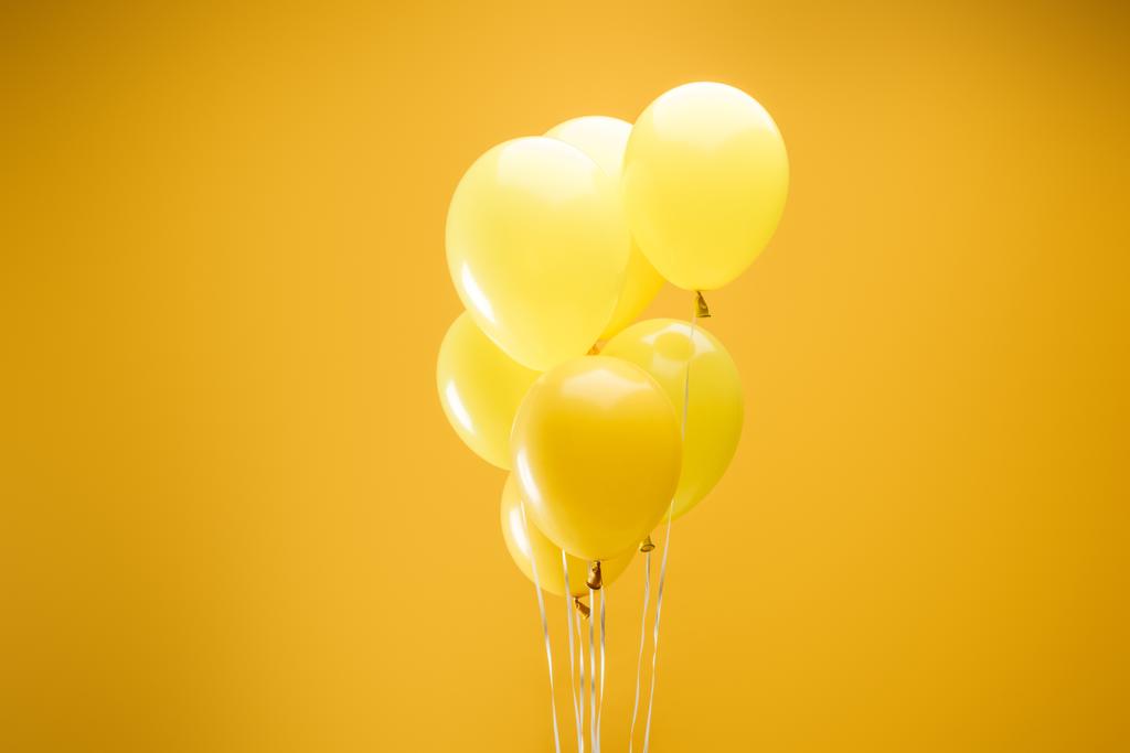 πολύχρωμα μινιμαλιστικά διακοσμητικά μπαλόνια σε κίτρινο φόντο - Φωτογραφία, εικόνα
