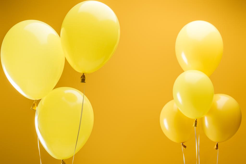 festive bright minimalistic balloons on yellow background - Photo, Image