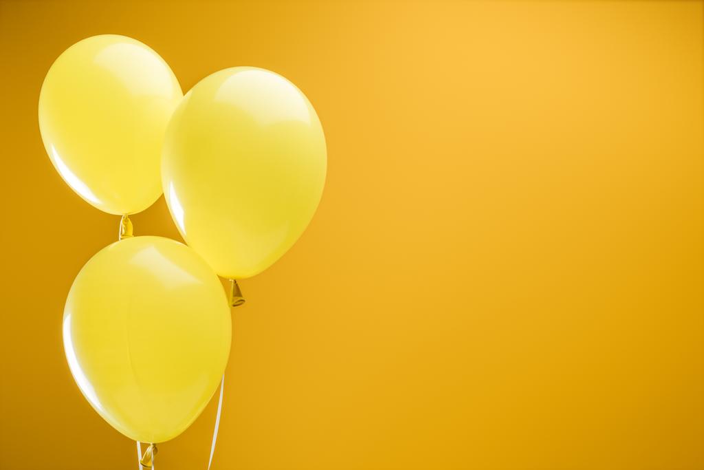 εορταστική φωτεινά μινιμαλιστική διακοσμητικά μπαλόνια σε κίτρινο φόντο με χώρο αντιγραφής - Φωτογραφία, εικόνα