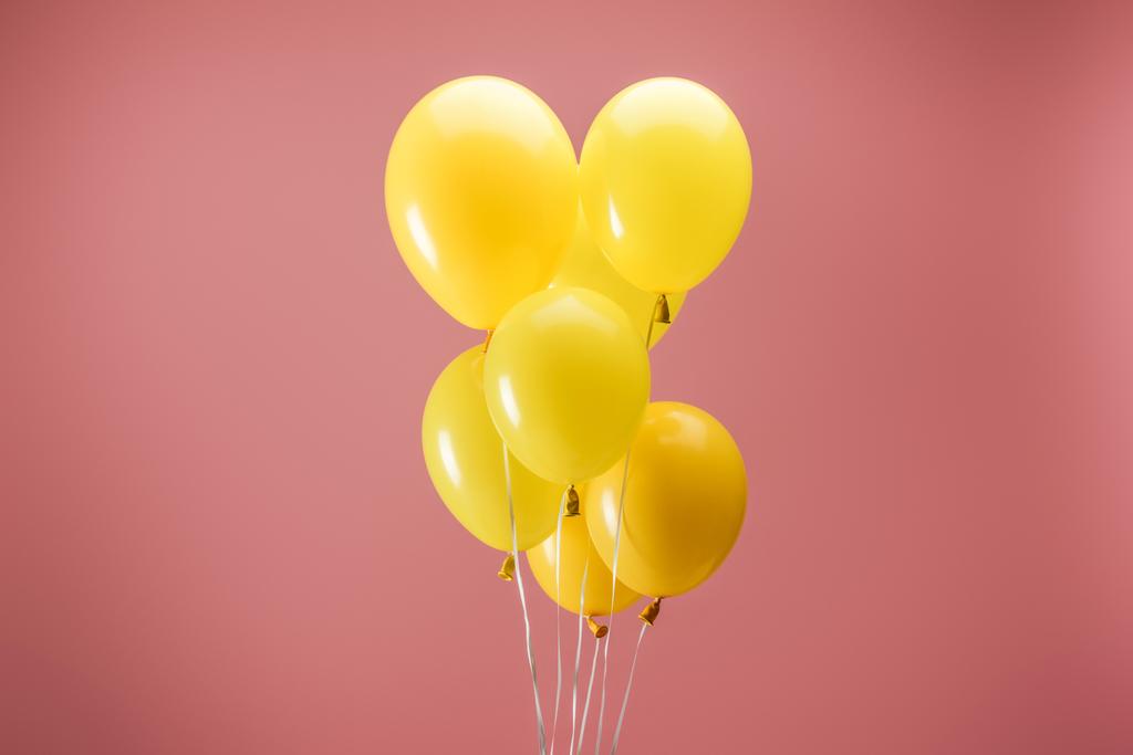 желтые яркие воздушные шары на розовом фоне, украшение вечеринки
 - Фото, изображение