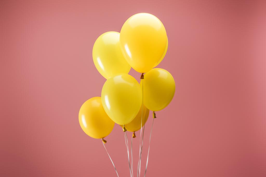 amarelo balões festivos brilhantes no fundo rosa, decoração do partido
 - Foto, Imagem