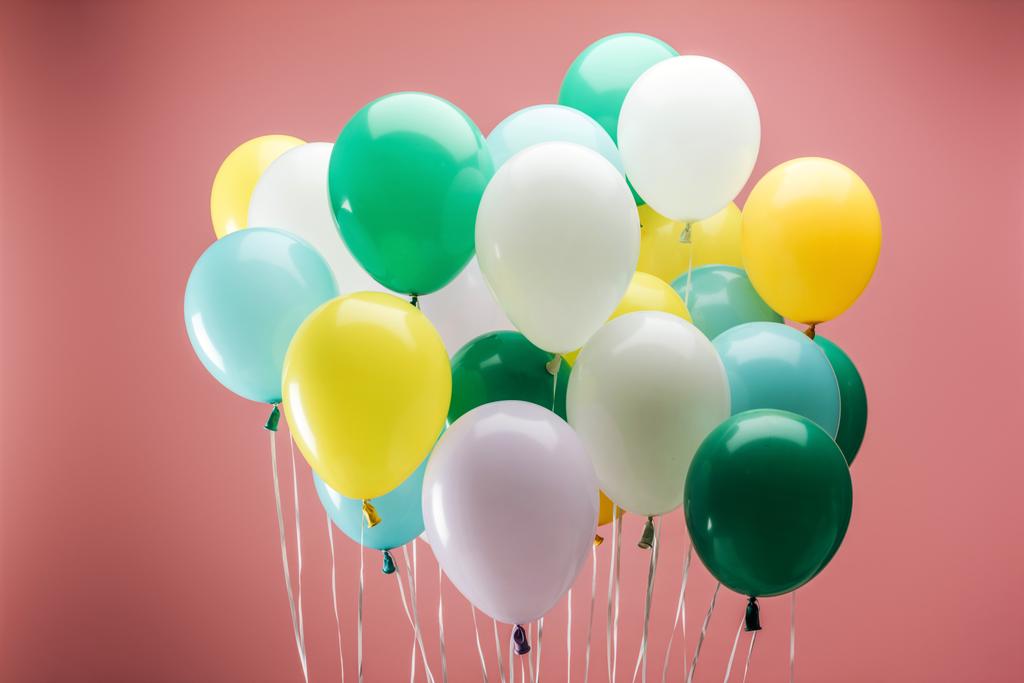 globos decorativos de color verde brillante, amarillo, blanco y azul sobre fondo rosa
 - Foto, imagen