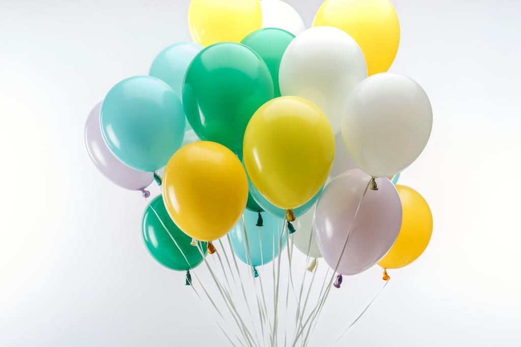 φωτεινά πράσινα, κίτρινα και μπλε διακοσμητικά μπαλόνια σε λευκό φόντο - Φωτογραφία, εικόνα