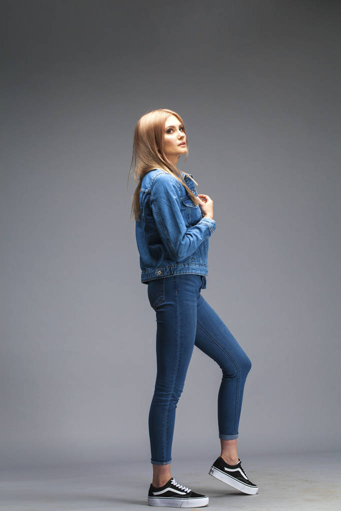 Mulher loira sexy bonita vestida com uma jaqueta jeans e azul j
 - Foto, Imagem