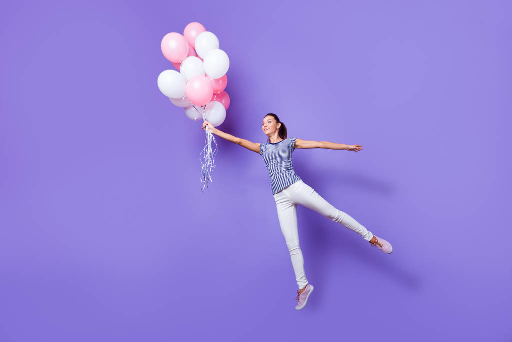 Ganzkörpergröße Ansicht Porträt von ihr sie schön attraktiv schöne modische fröhlich fröhlich Mädchen Spaß beim Fliegen mit Heliumkugeln isoliert über violett lila lebendigen Glanz hellen Hintergrund - Foto, Bild