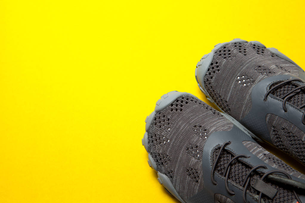 Один вид спорту сірі кросівки на жовтому тлі
 - Фото, зображення