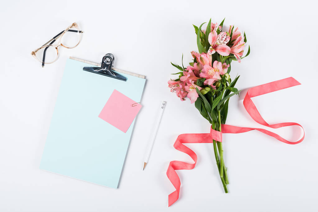 vista superior de flores, portapapeles, gafas, cinta, papel y lápiz en blanco
 - Foto, imagen