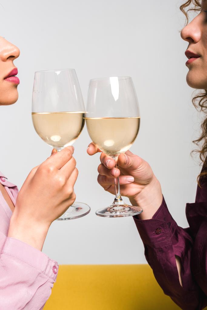 przycięte widok młodych kobiet szczęk kieliszki do szampana na białym  - Zdjęcie, obraz