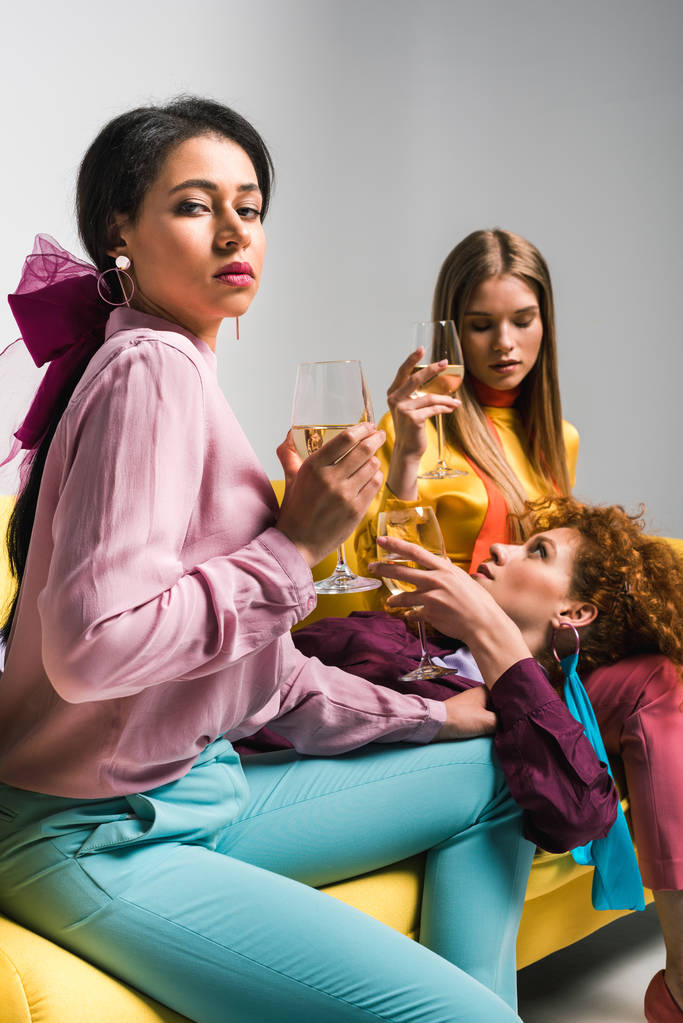valikoiva painopiste afrikkalainen amerikkalainen tyttö lähellä punapää ja blondi naiset samppanjaa lasit valkoinen
  - Valokuva, kuva