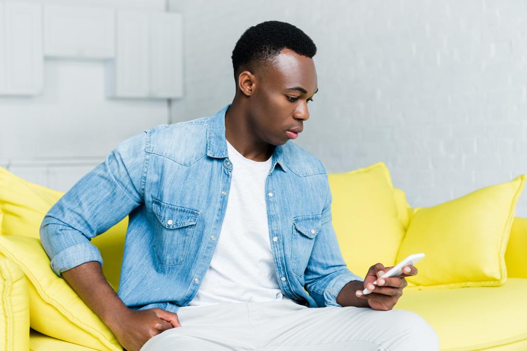 πλευρική όψη του αφρικανικού αμερικανικού ανθρώπου χρησιμοποιώντας smartphone - Φωτογραφία, εικόνα
