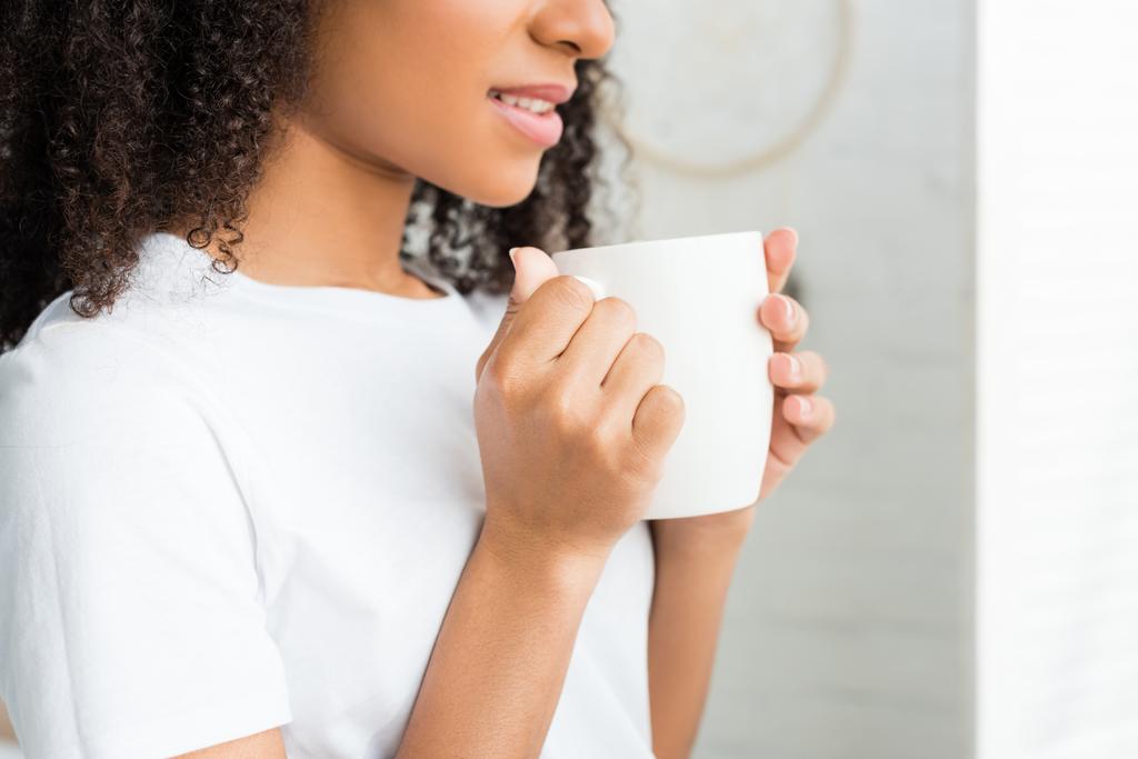 levágott kilátás nyugodt afro-amerikai nő, fehér csésze a kezében - Fotó, kép