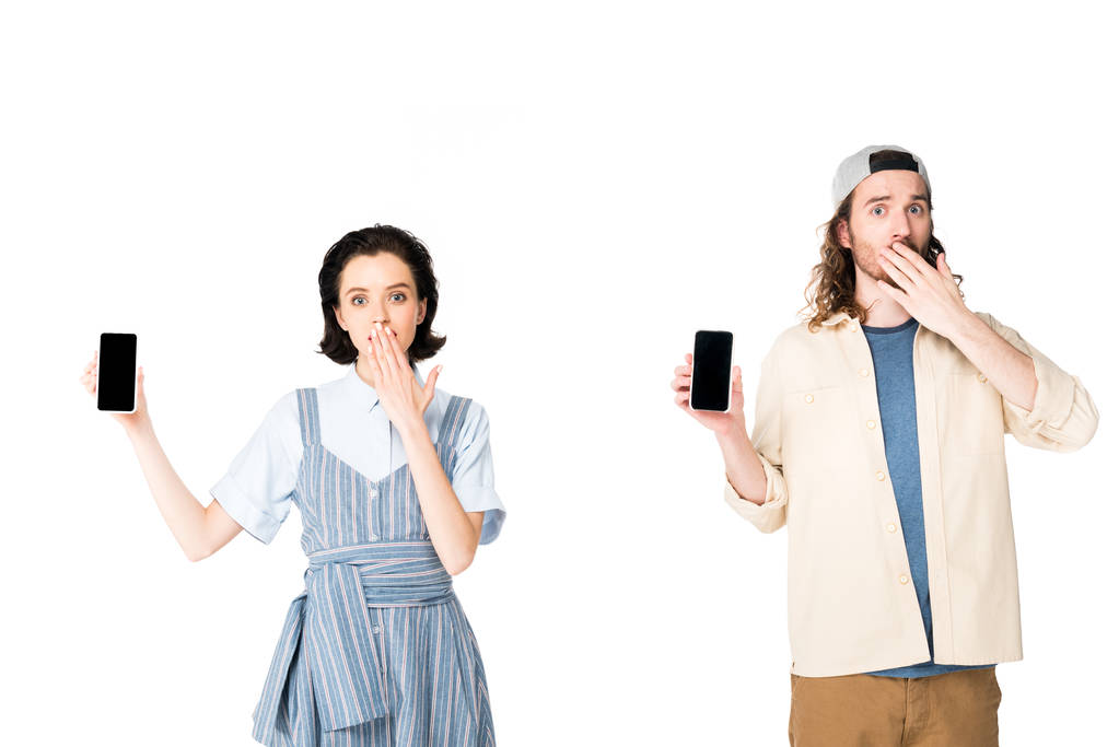 έκπληκτος νέος άντρας και κορίτσι κρατώντας smartphones σε χέρια που απομονώθηκαν σε λευκό - Φωτογραφία, εικόνα