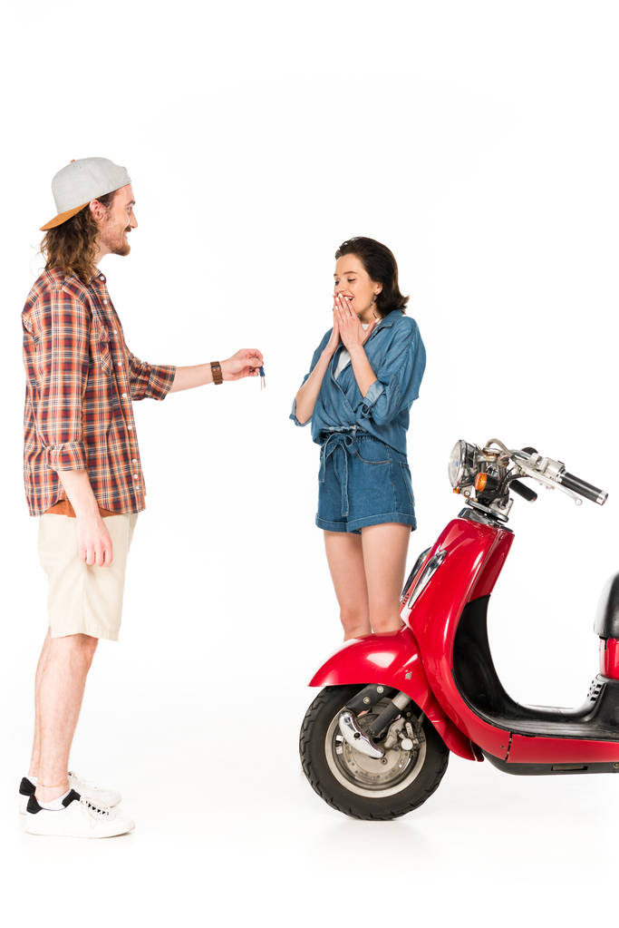 vue pleine longueur de jeune homme donnant des clés de scooter rouge à la fille isolée sur blanc
 - Photo, image