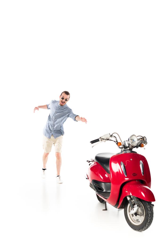 handsome stylish young man trying to grab red scooter isolated on white - Photo, Image