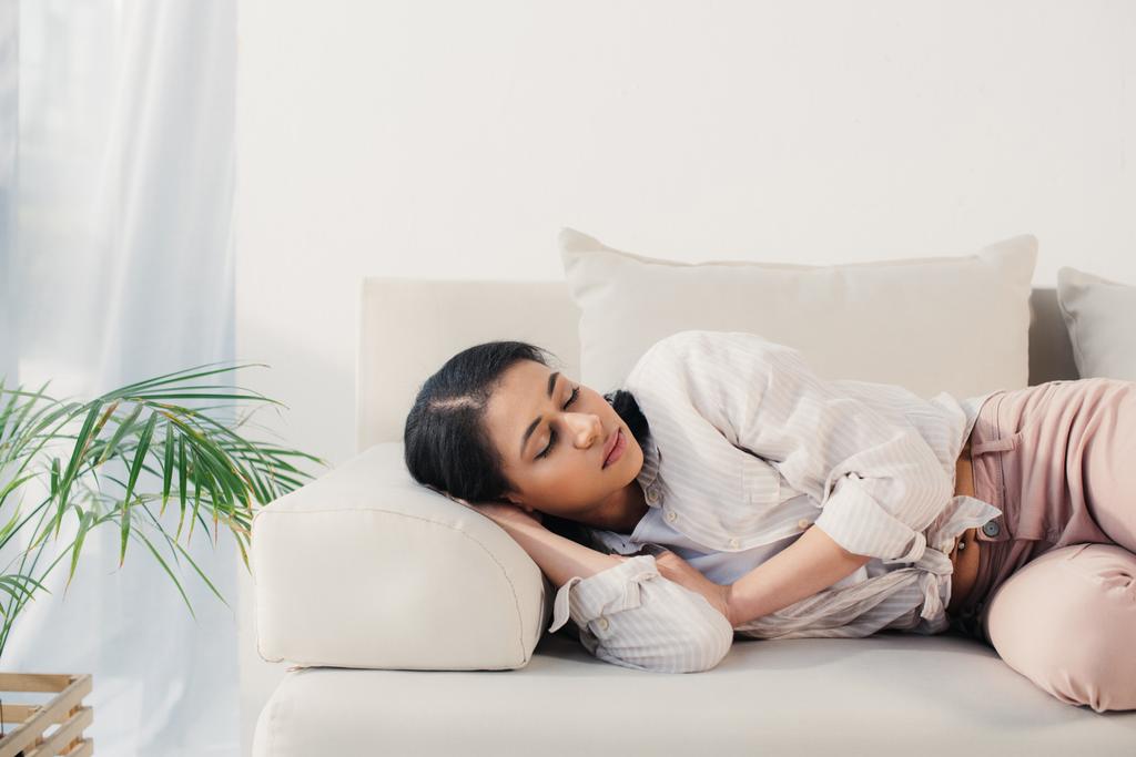kaunis väsynyt latino nainen makaa suljettujen silmien sohvalla kotona
 - Valokuva, kuva