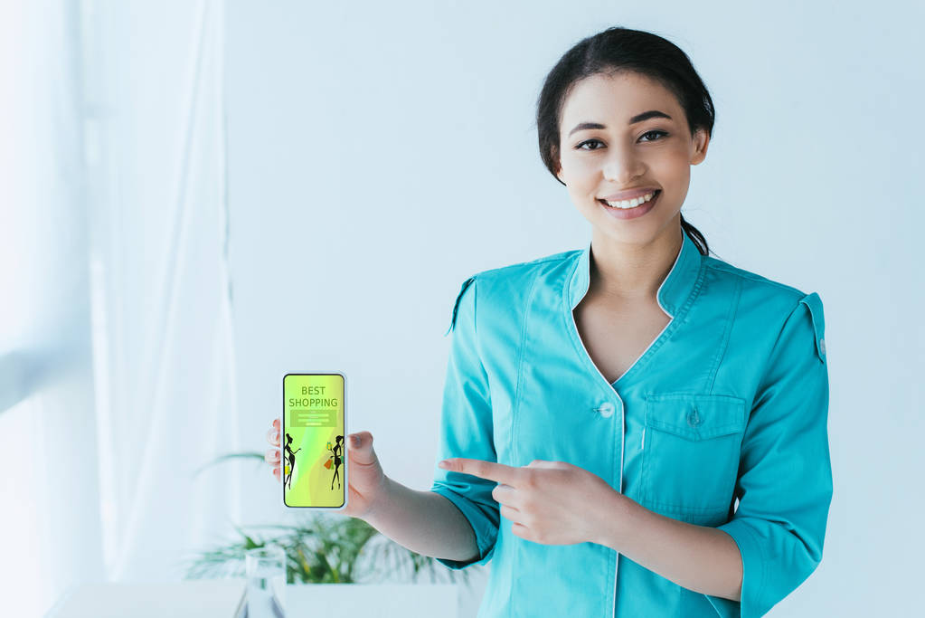 atraente médico latino segurando smartphone com melhor aplicativo de compras na tela
 - Foto, Imagem