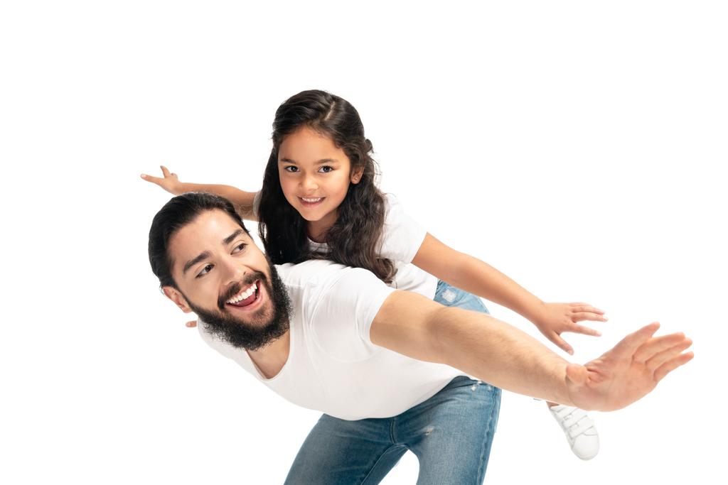 щасливий латинський батько носить на спині милу дочку з простягнутими руками ізольовано на білому
  - Фото, зображення