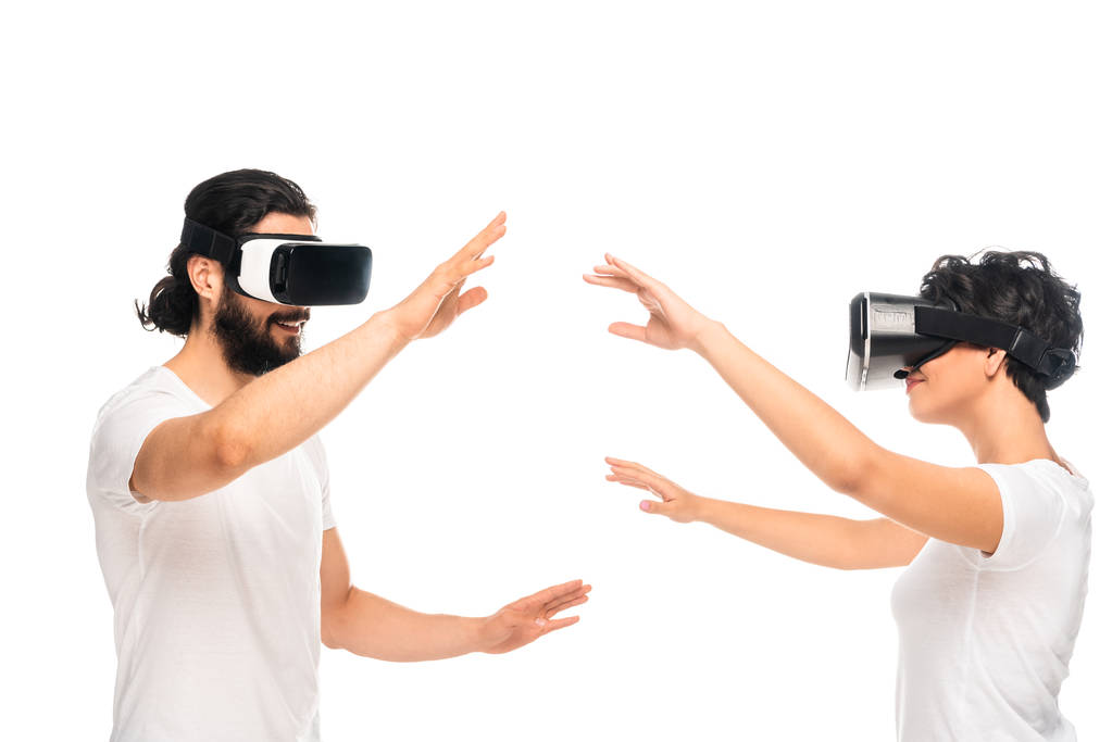 ευτυχισμένος Λάτιν άντρας και γυναίκα φορώντας ακουστικά εικονικής πραγματικότητας και τη χειρονομία που απομονώνονται σε λευκό  - Φωτογραφία, εικόνα