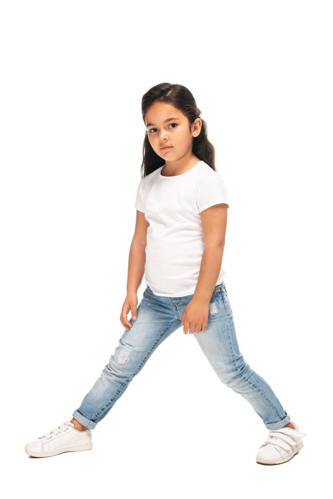adorabile bambino latino in piedi in jeans blu isolato su bianco
  - Foto, immagini
