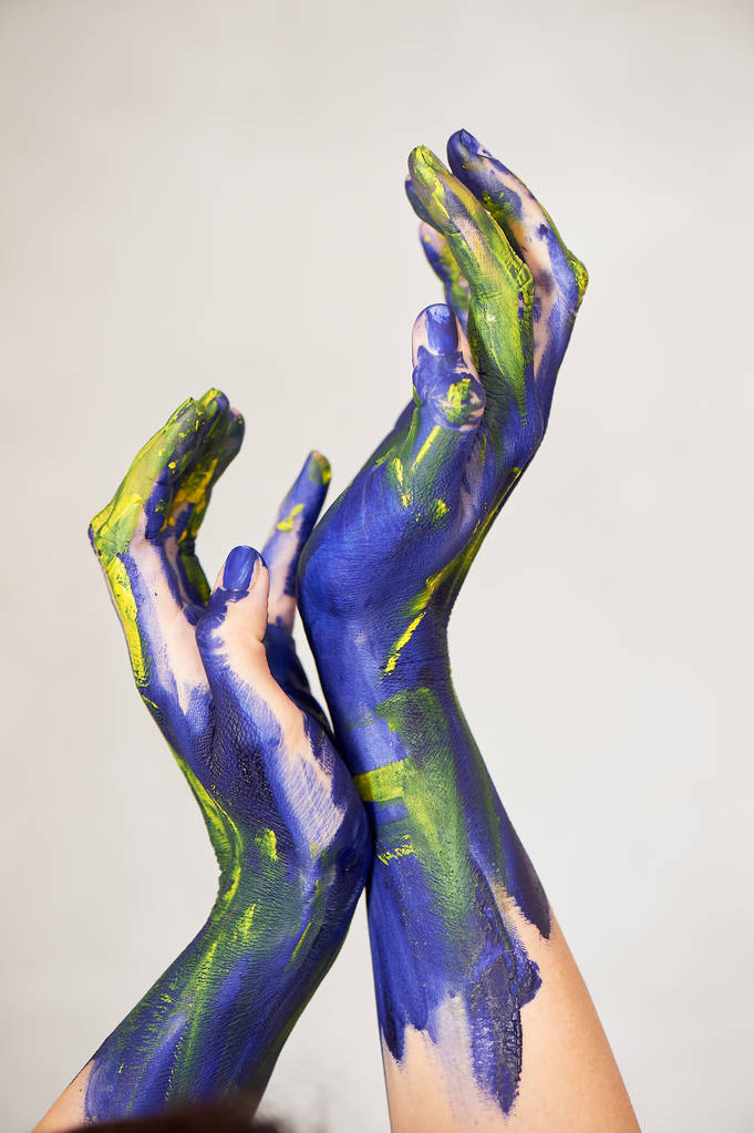 Hände in blauer Farbe mit gelben Akzenten, Hände des Künstlers und kreativer Person.Yoga für Hände - Foto, Bild