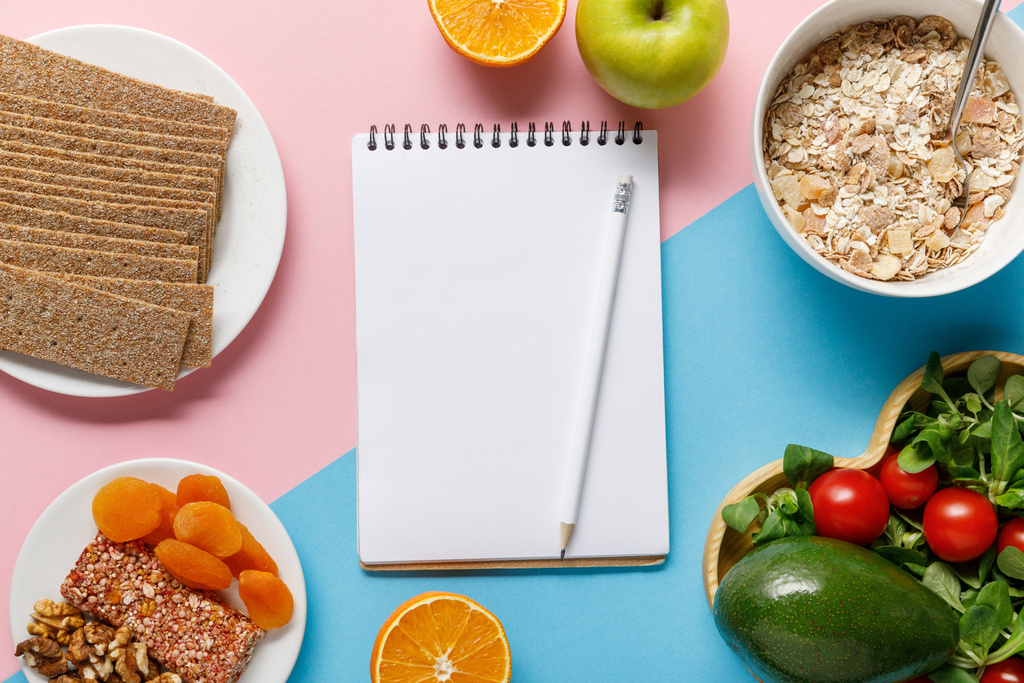 top view of empty notebook and pencil with tasty diet food on blue and pink background  - Photo, Image