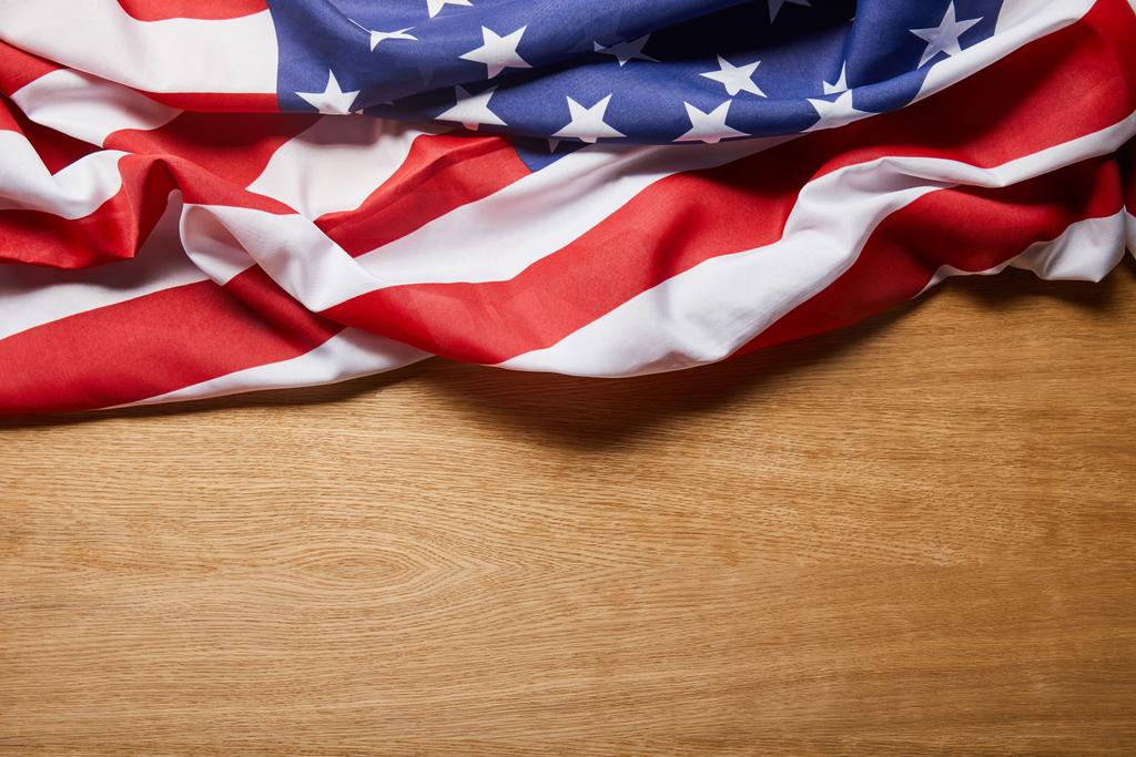 bovenaanzicht van de Amerikaanse vlag op beige houten tafel met Kopieer ruimte - Foto, afbeelding