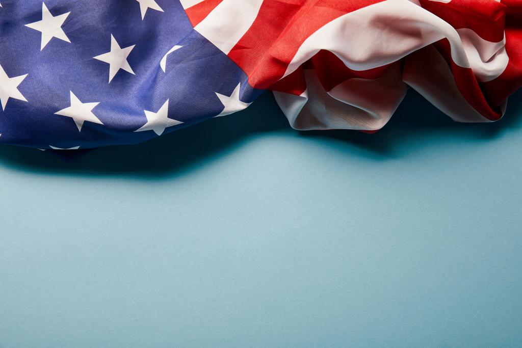 lähikuva rypistynyt Amerikan lippu sinisellä pohjalla kopioi tilaa
 - Valokuva, kuva