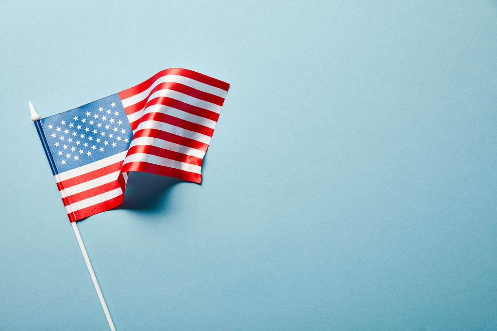 vista superior da bandeira dos EUA na vara no fundo azul com espaço de cópia
 - Foto, Imagem