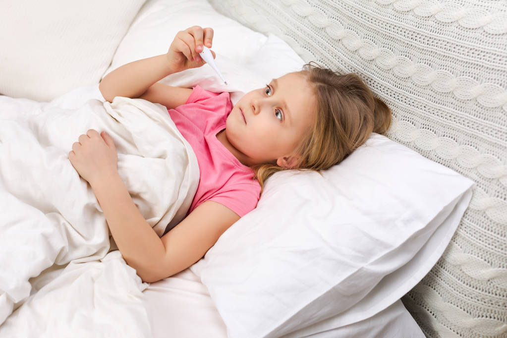 温度計付きのベッドで横になっている病気の少女 - 写真・画像