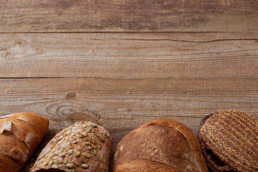 čerstvé pečené bochníky lahodného chleba na dřevěném venkovním stole - Fotografie, Obrázek