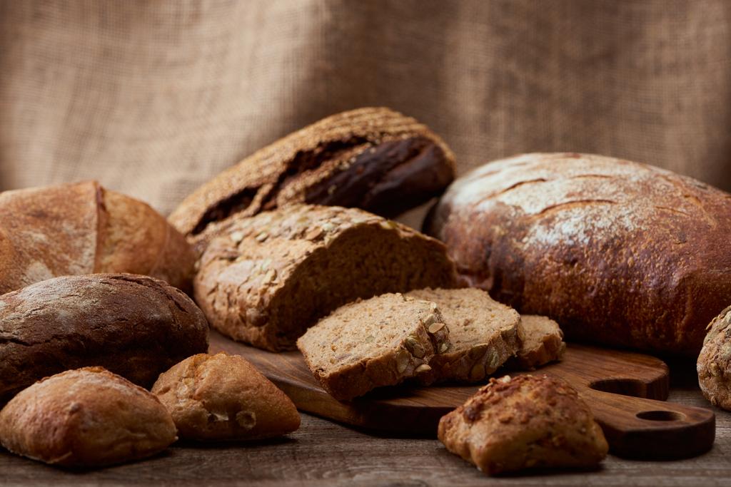 смачні хліби хліба на дерев'яній дошці з мішковиною на фоні
 - Фото, зображення