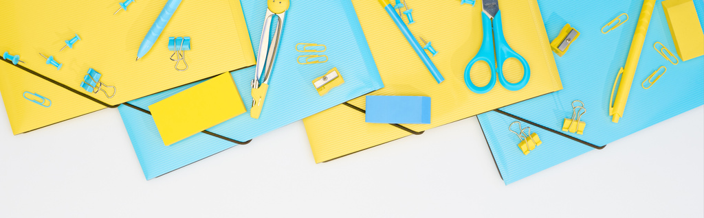 tiro panorâmico de papelaria azul e amarelo isolado em branco
 - Foto, Imagem