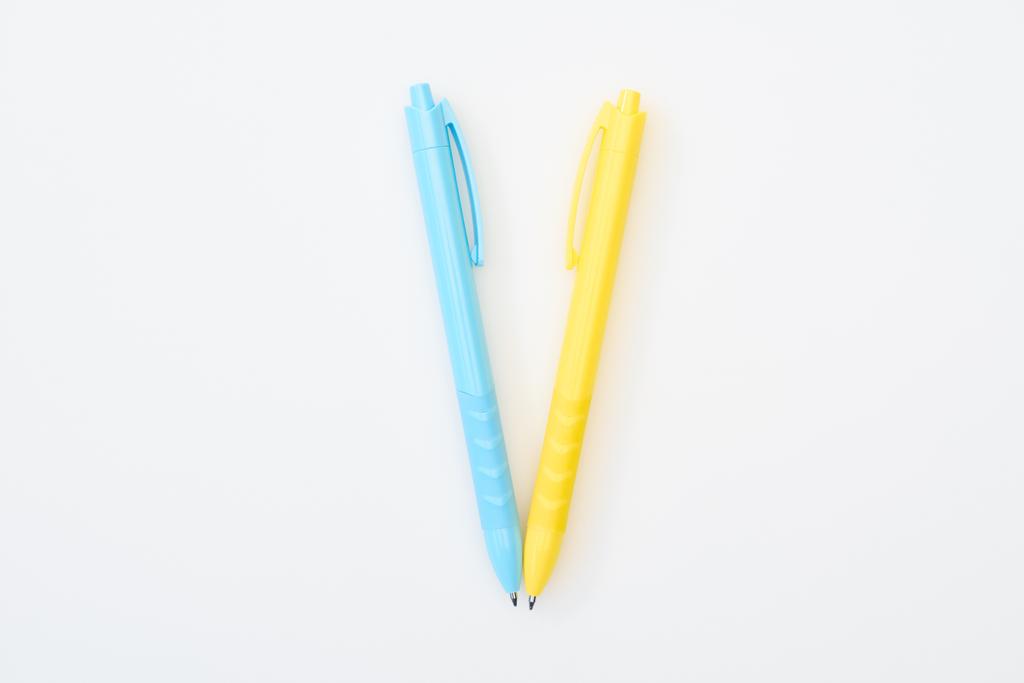 верхний вид желтого и синего скрещенных карандашей изолированы на белый
 - Фото, изображение