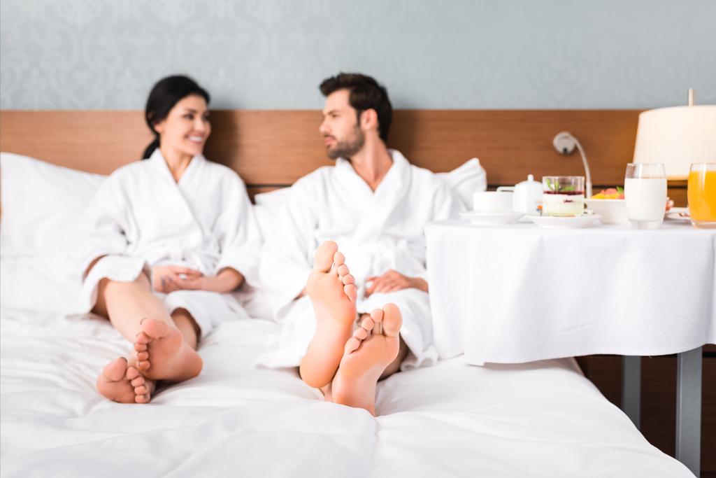 szelektív középpontjában boldog férfi és nő nézi egymást az asztal közelében a reggelivel  - Fotó, kép
