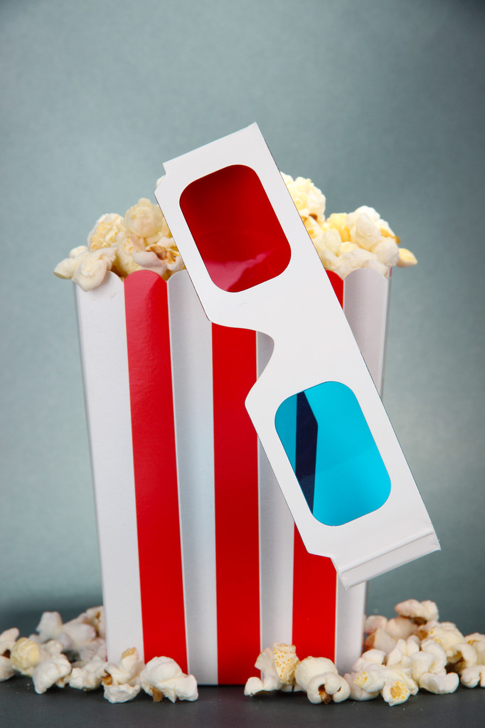 Popcorn en 3D-bril op grijze achtergrond - Foto, afbeelding