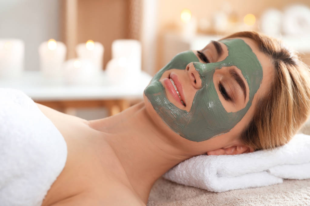 Beautiful woman with mask on face relaxing in spa salon - Photo, Image