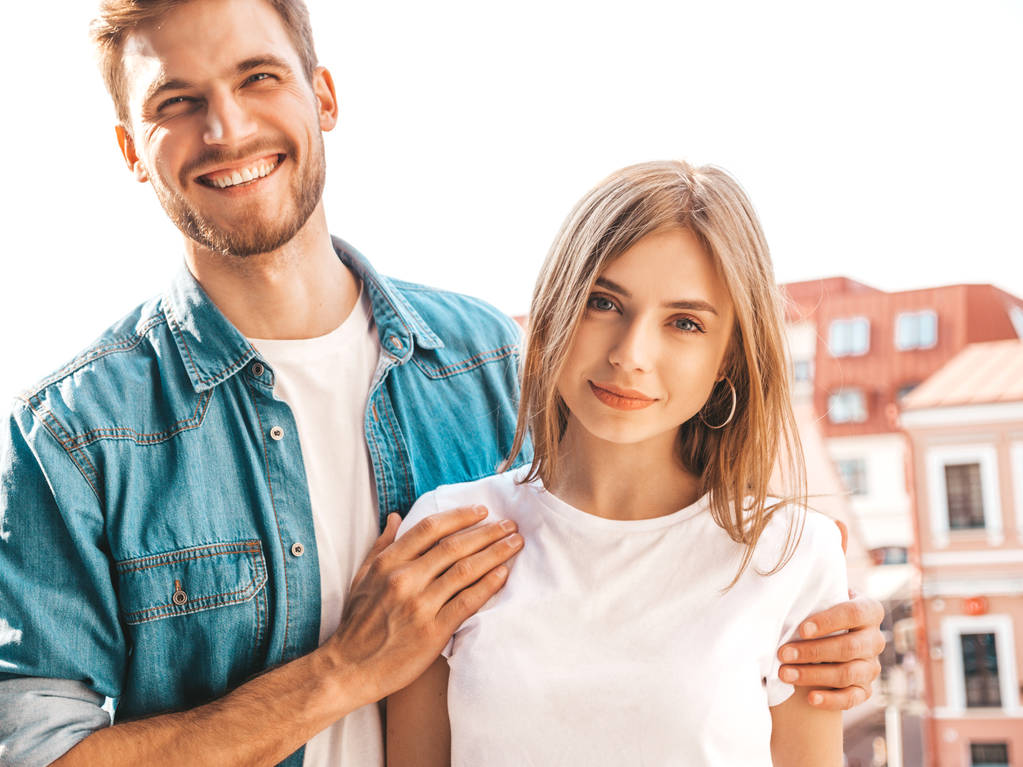 Portret van glimlachend mooi meisje en haar knappe vriendje. Vrouw in Casual zomer jeans kleding. Gelukkig vrolijke familie. Vrouw met plezier op de straat achtergrond. Naar elkaar kijken - Foto, afbeelding