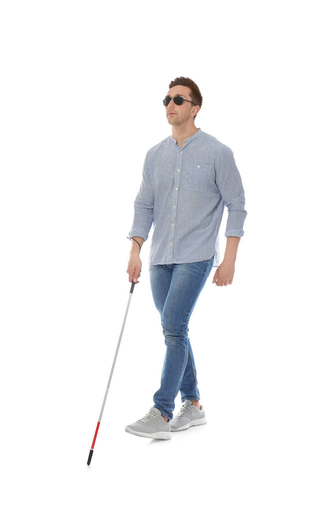 Молодой слепой человек с длинной тростью ходит на белом фоне
 - Фото, изображение