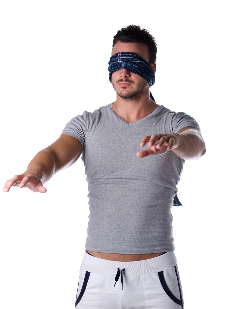 Blindfolded young man feeling his way in the dark - Photo, Image
