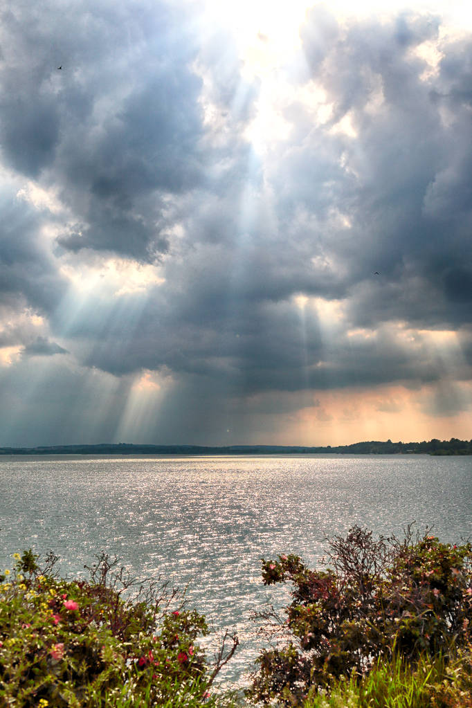 Zapora wodna na jeziorze Mietkow (w pobliżu Wrocławia, Polska) w ostatnich dniach maja. Piękne chmury burzy i promienie słoneczne. - Zdjęcie, obraz