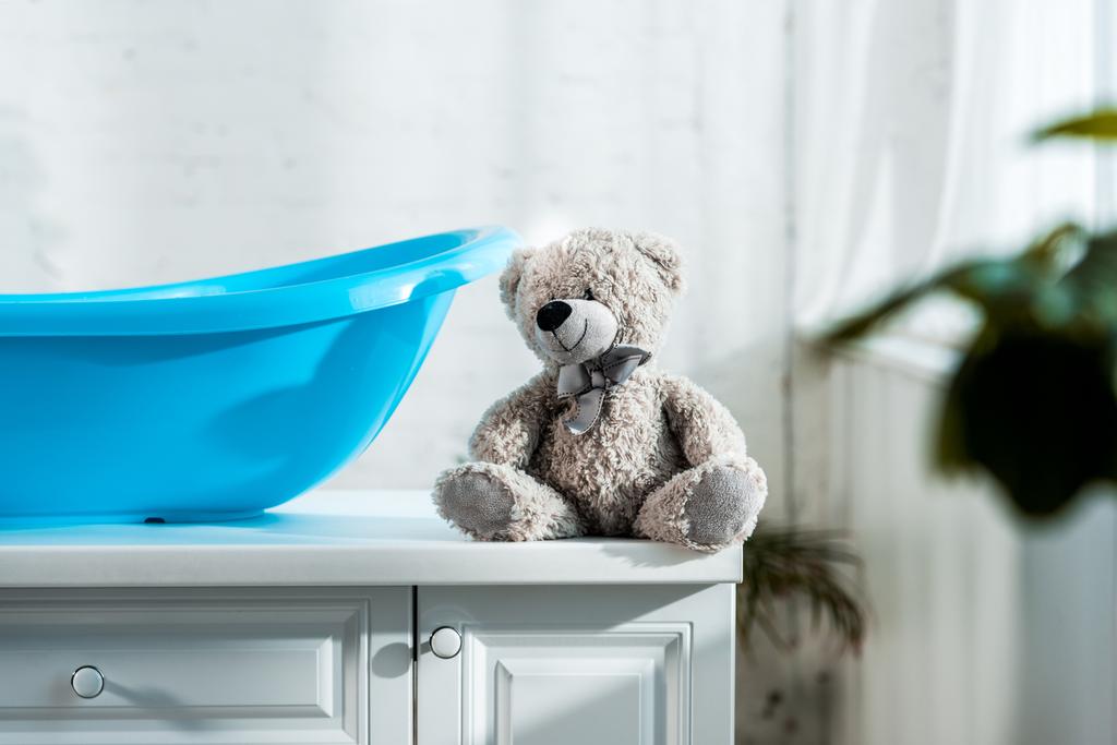 válogatós összpontosít mackó mellett kék baba fürdőkád-ban fürdőszoba - Fotó, kép