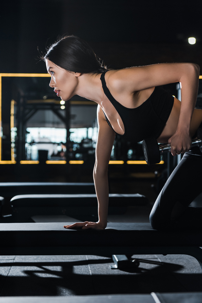 красивая и спортивная женщина тренируется с гантелями в спортзале
  - Фото, изображение