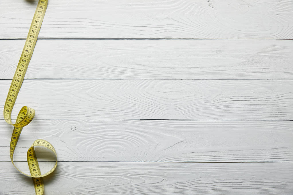 top view yellow measuring tape on wooden white surface with copy space - Photo, Image