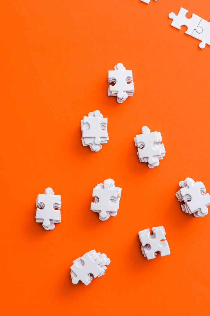 top view of stacks with white puzzle pieces on orange - Photo, Image