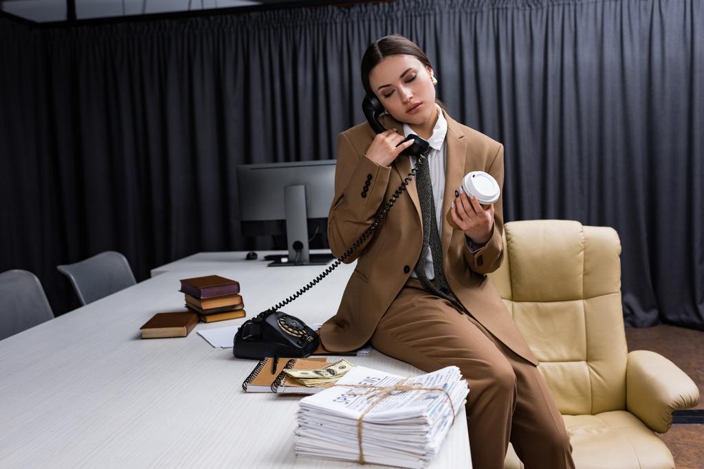 adult businesswoman with paper cup in hand closing eyes, talking on phone - Photo, Image