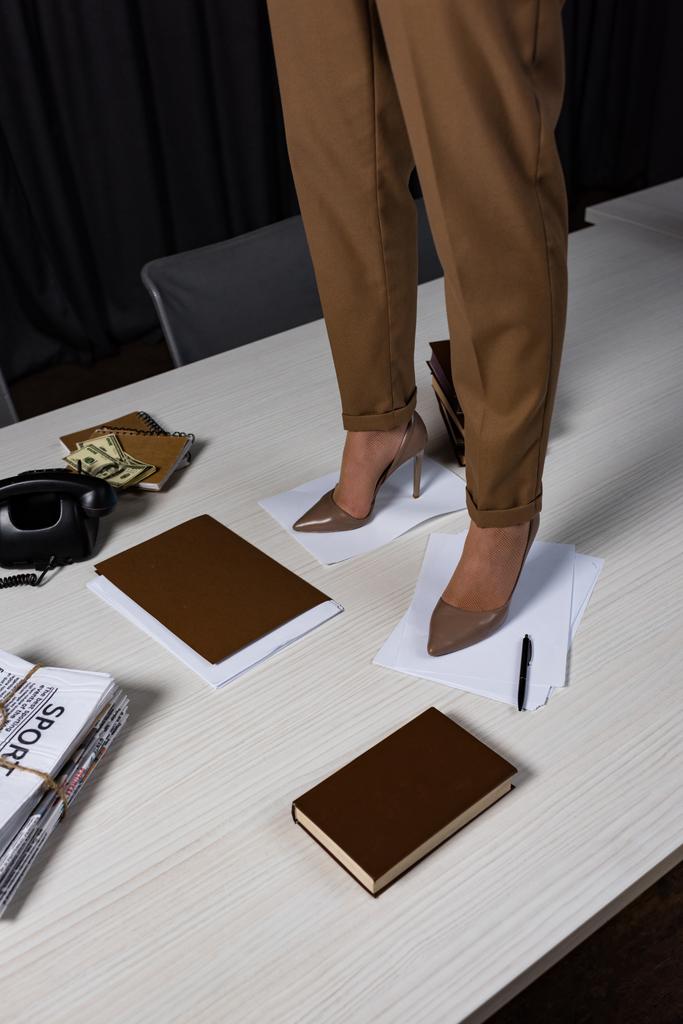 обрезанный вид бизнесвумен, стоящих на белом столе в офисе
 - Фото, изображение