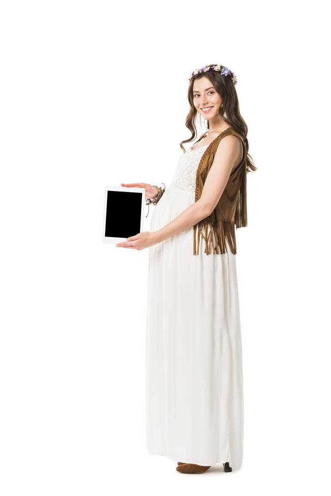 volle Länge Ansicht der lächelnden schwangeren Hippie-Frau mit digitalem Tablet mit leerem Bildschirm isoliert auf weiß - Foto, Bild